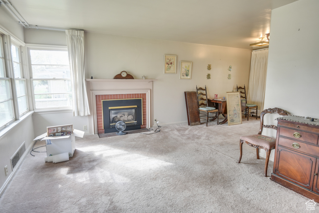 Carpeted living room with a brick fireplace