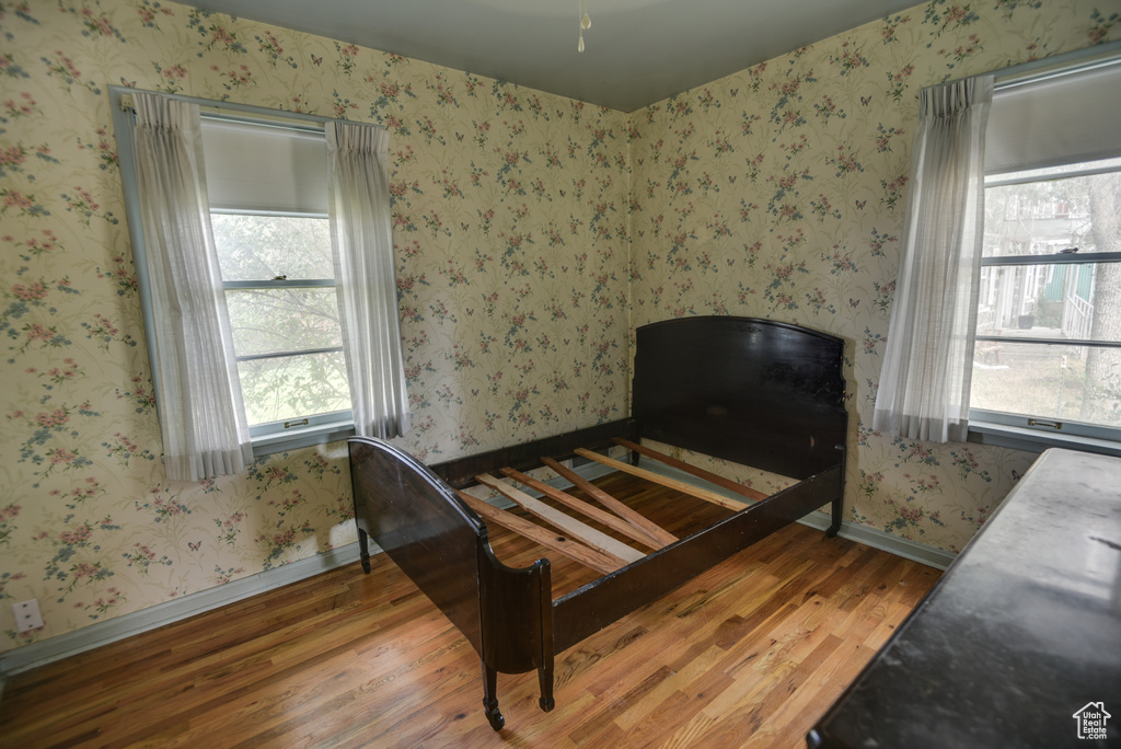 Bedroom featuring hardwood / wood-style flooring and multiple windows