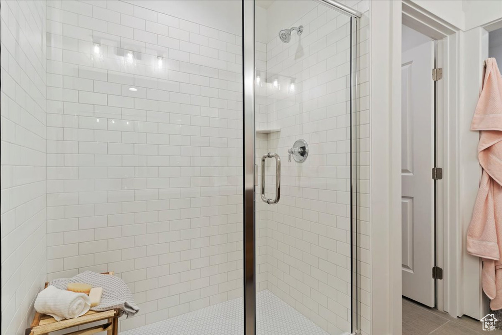 Bathroom with a shower with door and tile patterned floors