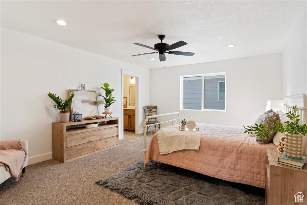 Carpeted bedroom with ensuite bathroom and ceiling fan