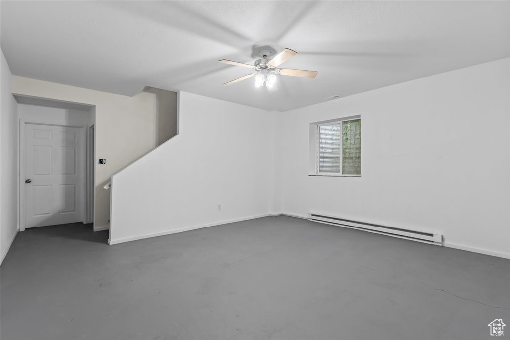 Spare room with a baseboard heating unit and ceiling fan