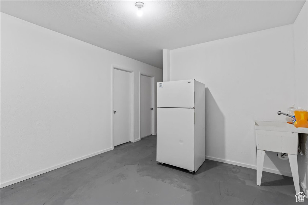 Interior space featuring a textured ceiling and concrete floors