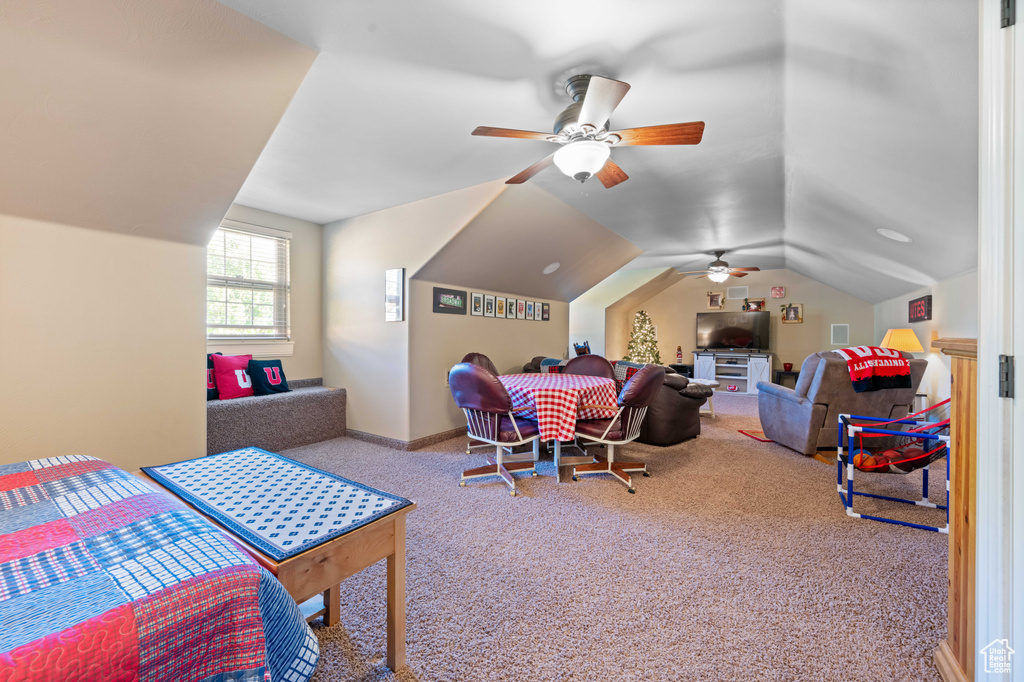 Carpeted bedroom with ceiling fan and lofted ceiling