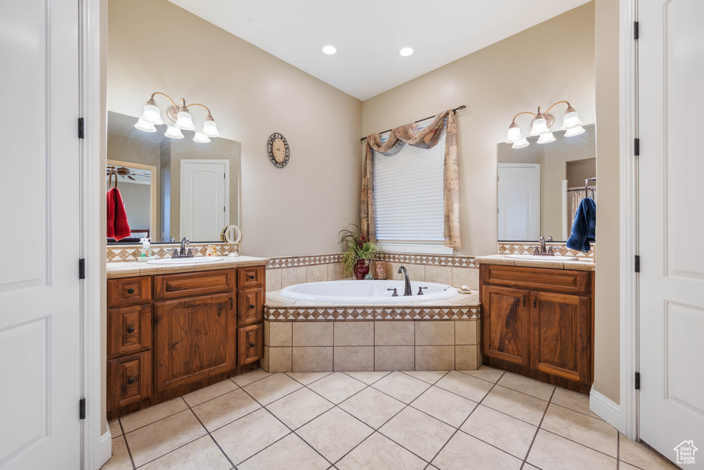 Bathroom with vanity, tile patterned flooring, and tiled tub