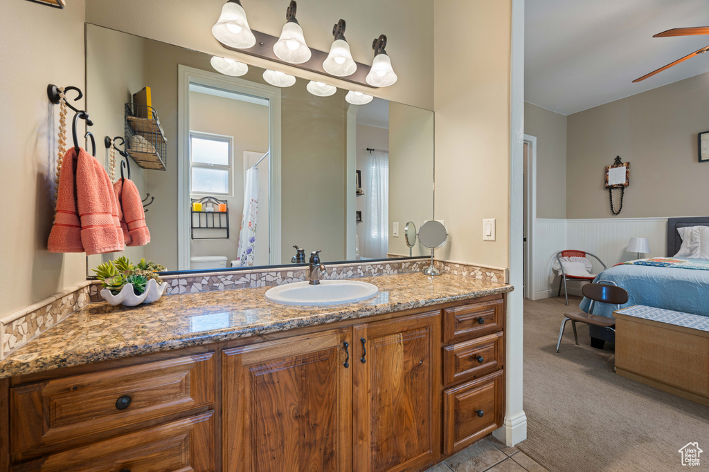 Bathroom with an inviting chandelier, vanity, toilet, and walk in shower