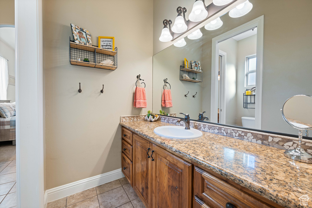 Bathroom featuring vanity, toilet, and tile patterned flooring