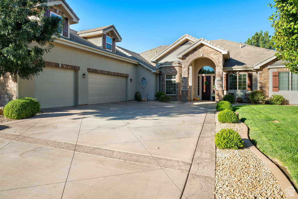 View of front of house featuring a garage and a front lawn