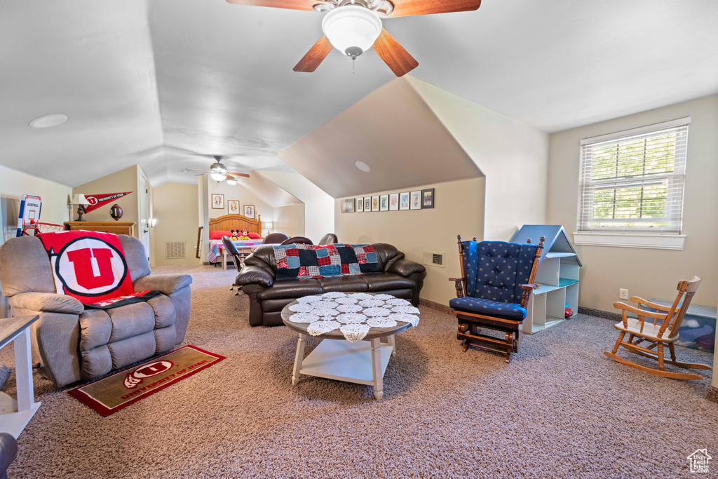 Carpeted living room featuring ceiling fan and lofted ceiling