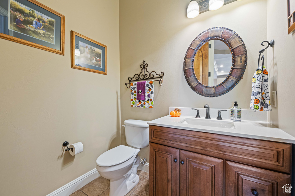 Bathroom with vanity, toilet, and tile patterned floors