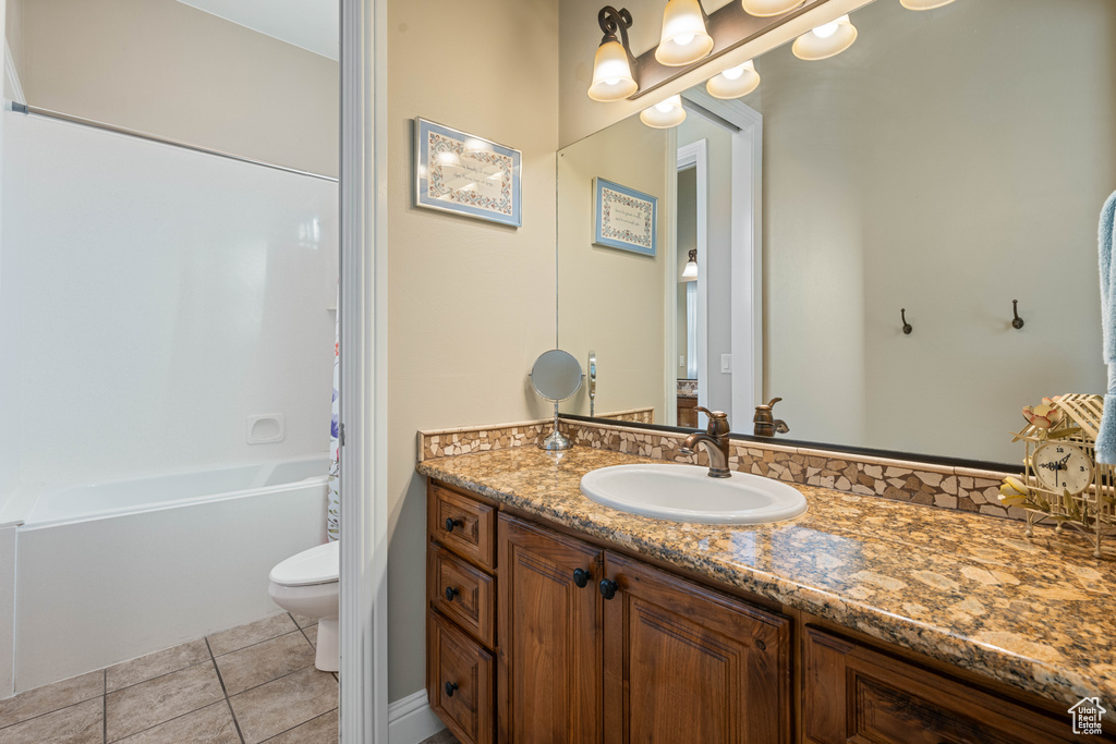 Full bathroom with toilet, vanity, shower / bathtub combination with curtain, and tile patterned flooring