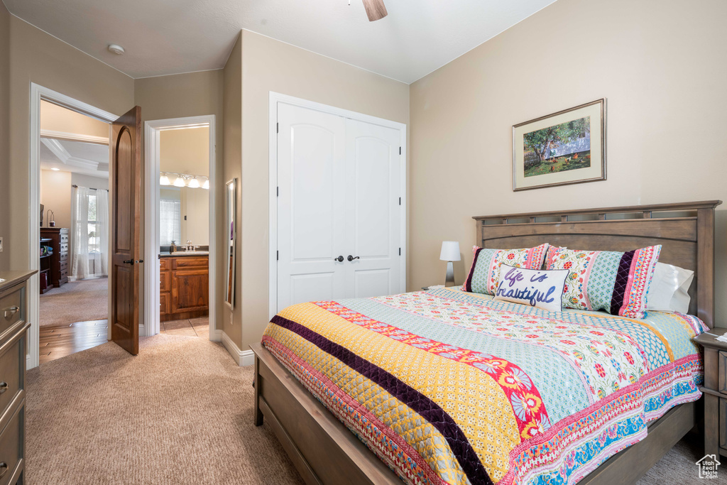 Carpeted bedroom featuring a closet, ceiling fan, and ensuite bathroom