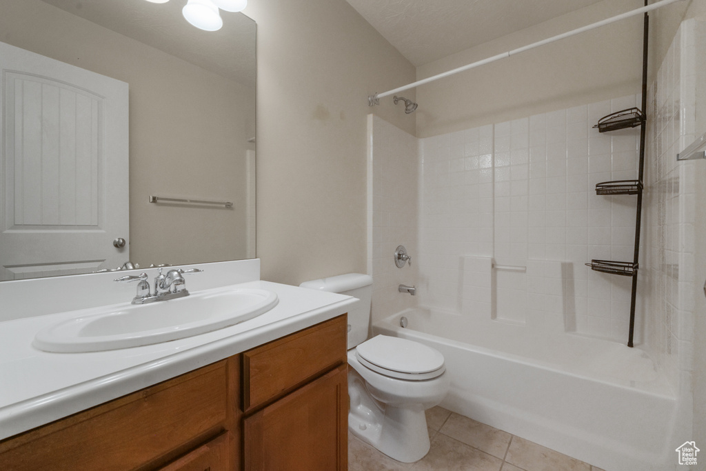 Full bathroom with toilet, vanity,  shower combination, and tile patterned flooring