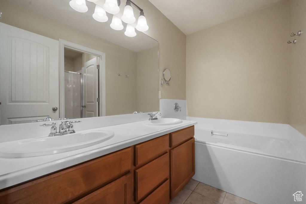 Bathroom featuring vanity, shower with separate bathtub, and tile patterned floors