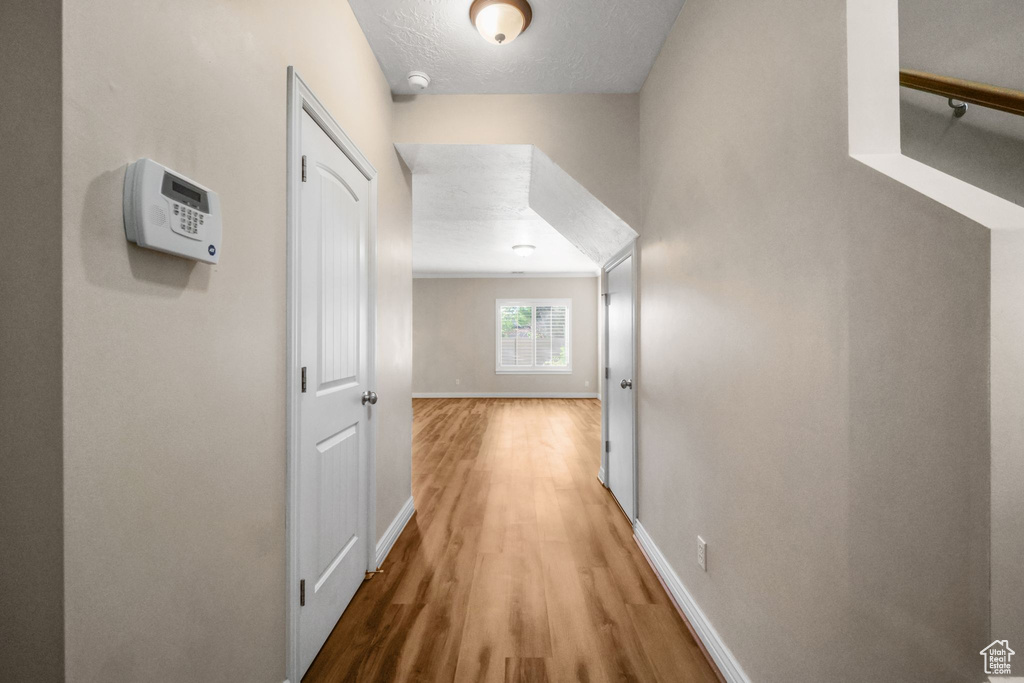 Corridor featuring wood-type flooring and a textured ceiling