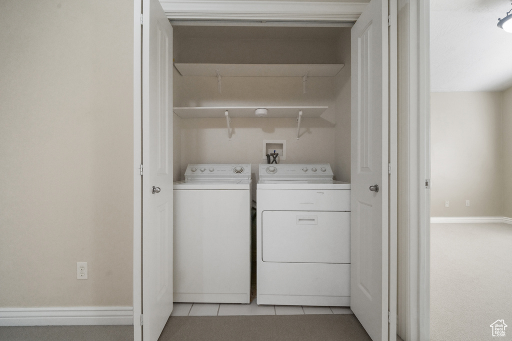 Laundry area featuring independent washer and dryer and light tile patterned floors