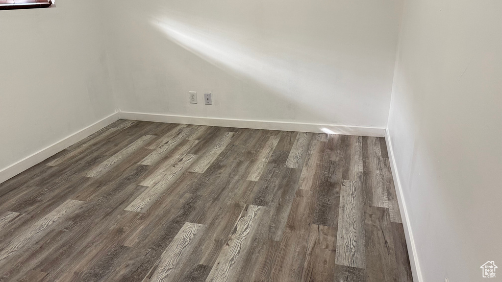 Empty room featuring dark wood-type flooring