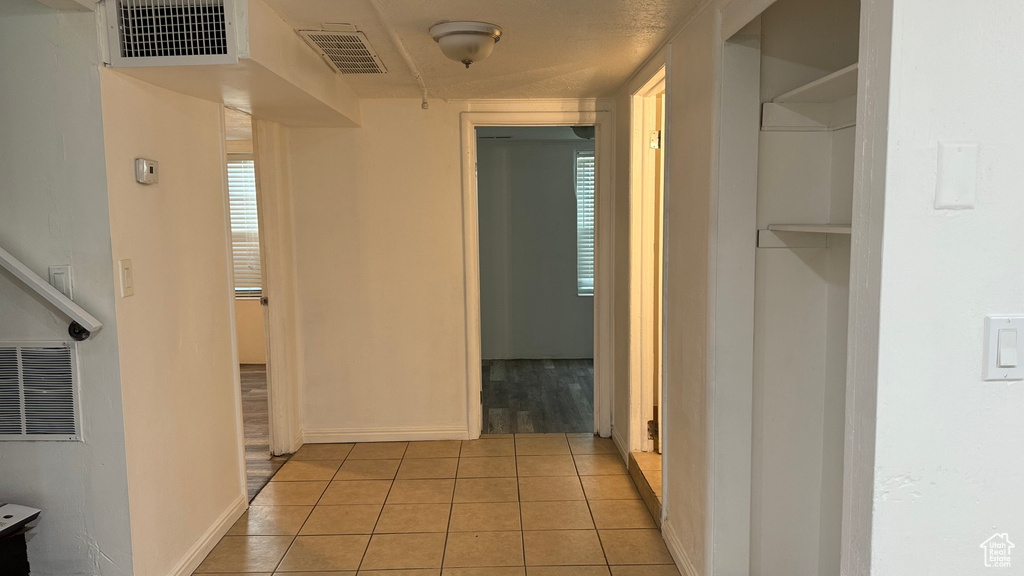 Hall featuring light tile patterned flooring