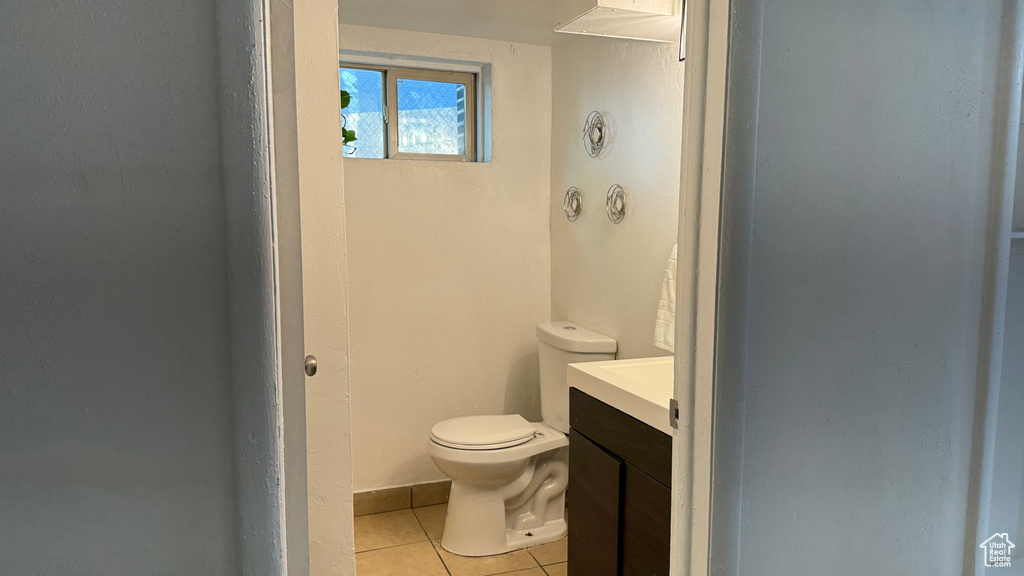 Bathroom with vanity, toilet, and tile patterned flooring