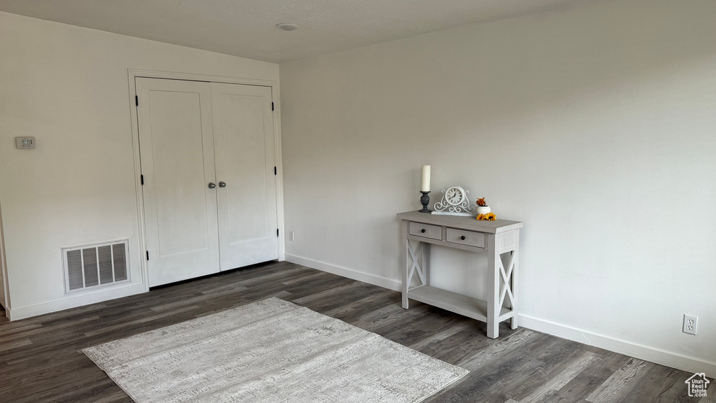 Unfurnished bedroom with a closet and dark hardwood / wood-style flooring