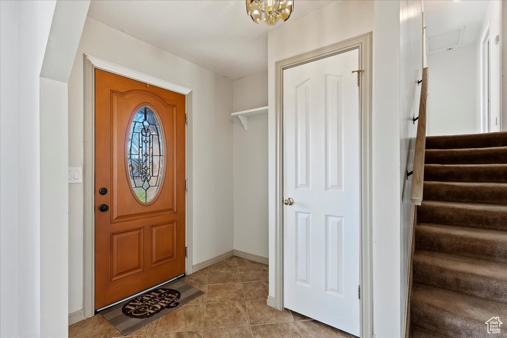 Tiled entrance foyer featuring a notable chandelier