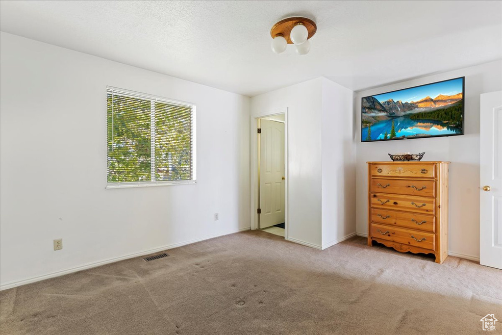 Unfurnished bedroom featuring light carpet