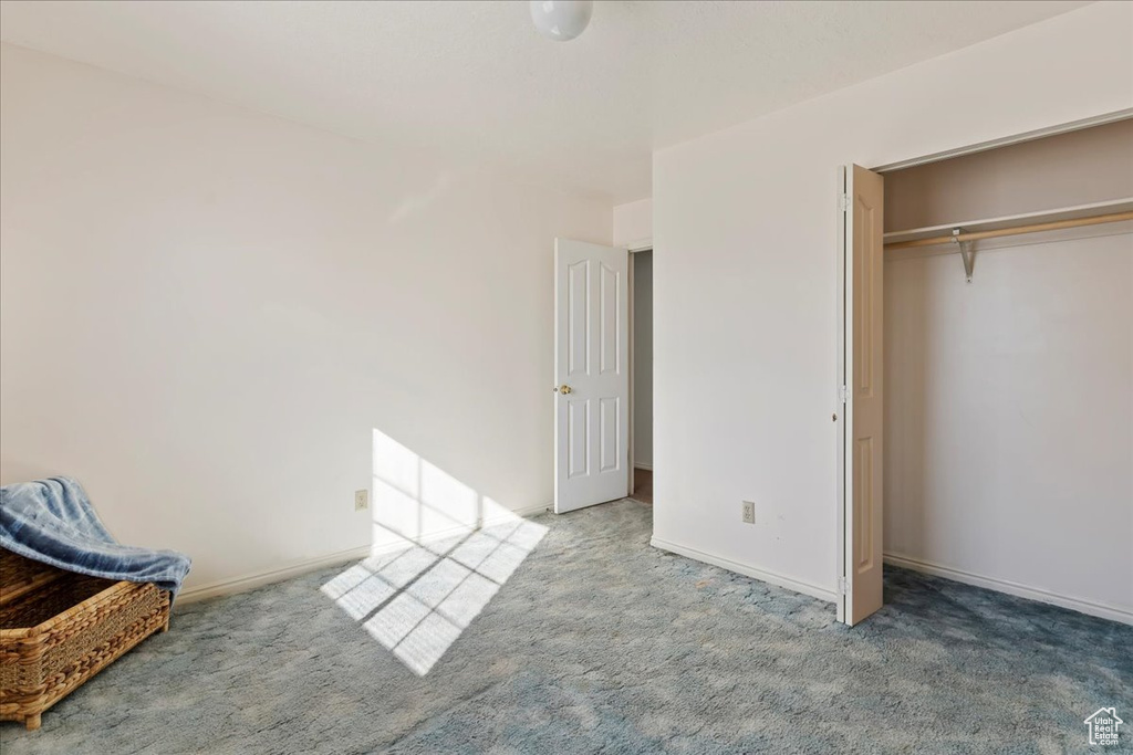 Unfurnished bedroom featuring carpet and a closet