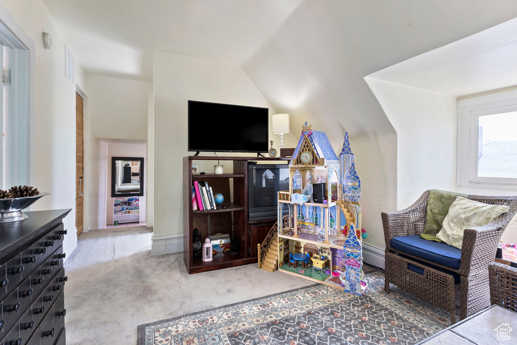 Carpeted living room featuring lofted ceiling