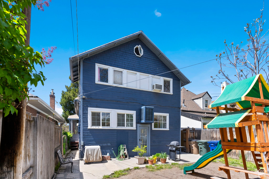 Back of house with a patio, cooling unit, and a playground