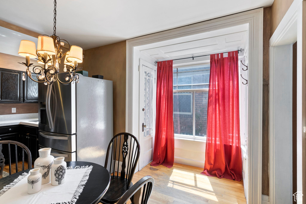 Dining room with an inviting chandelier, light hardwood / wood-style flooring, and plenty of natural light