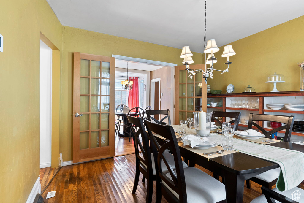 Dining room with a notable chandelier and dark hardwood / wood-style flooring