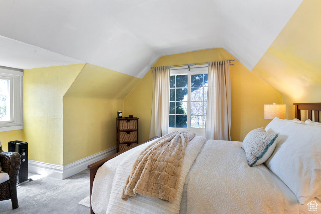 Bedroom with lofted ceiling and light carpet