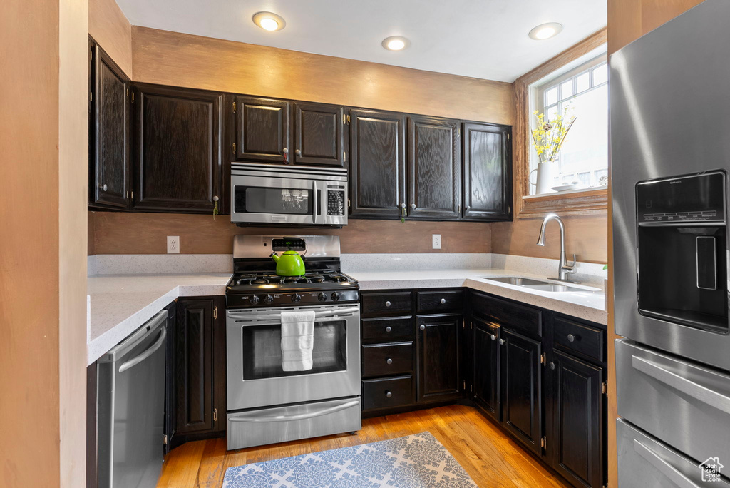 Kitchen featuring appliances with stainless steel finishes, light hardwood / wood-style flooring, and sink