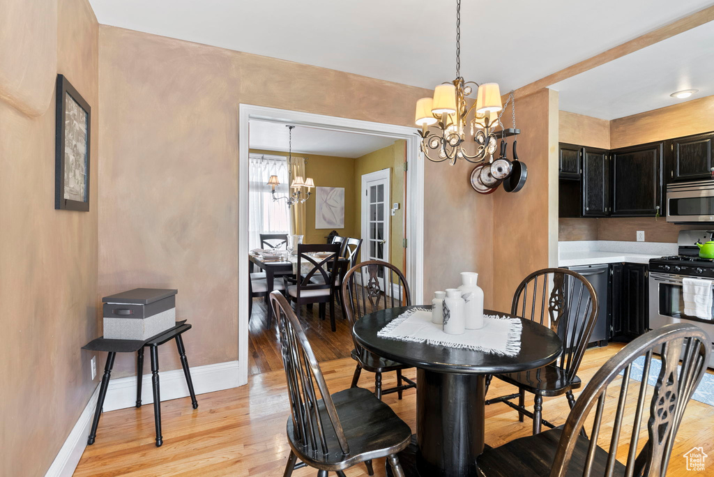 Dining room featuring an inviting chandelier and light hardwood / wood-style flooring