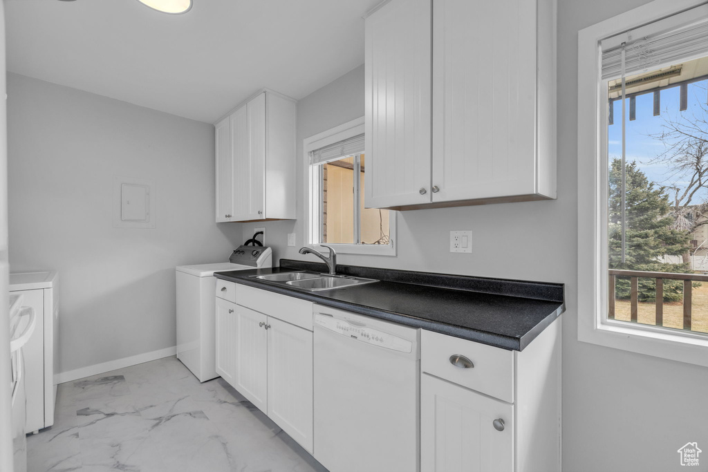 Kitchen featuring white cabinetry, a healthy amount of sunlight, white dishwasher, and sink