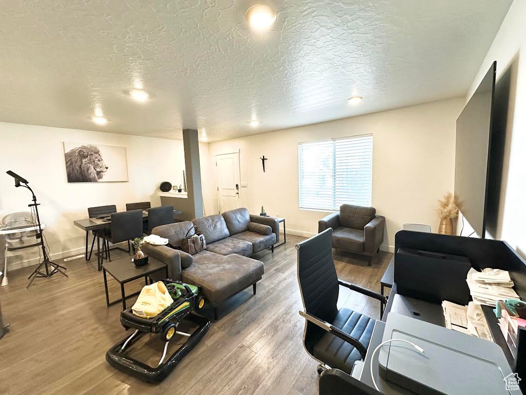 Living room featuring hardwood / wood-style flooring and a textured ceiling