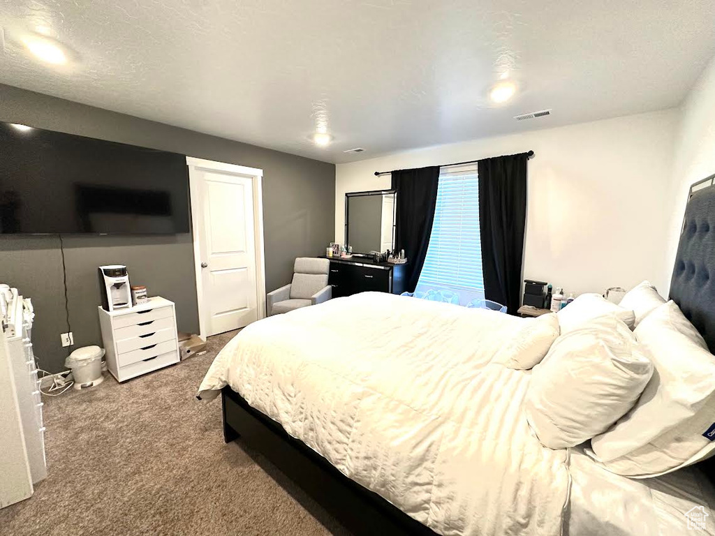 Bedroom with carpet and a textured ceiling