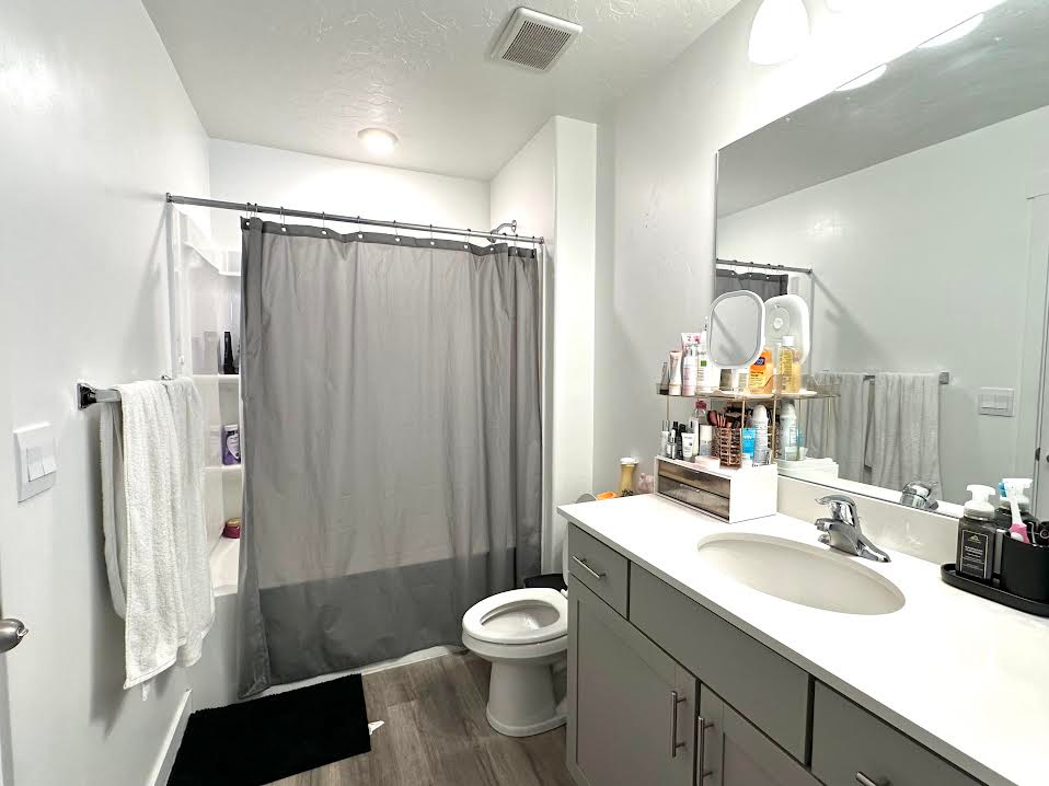 Bathroom with toilet, a textured ceiling, hardwood / wood-style flooring, and vanity