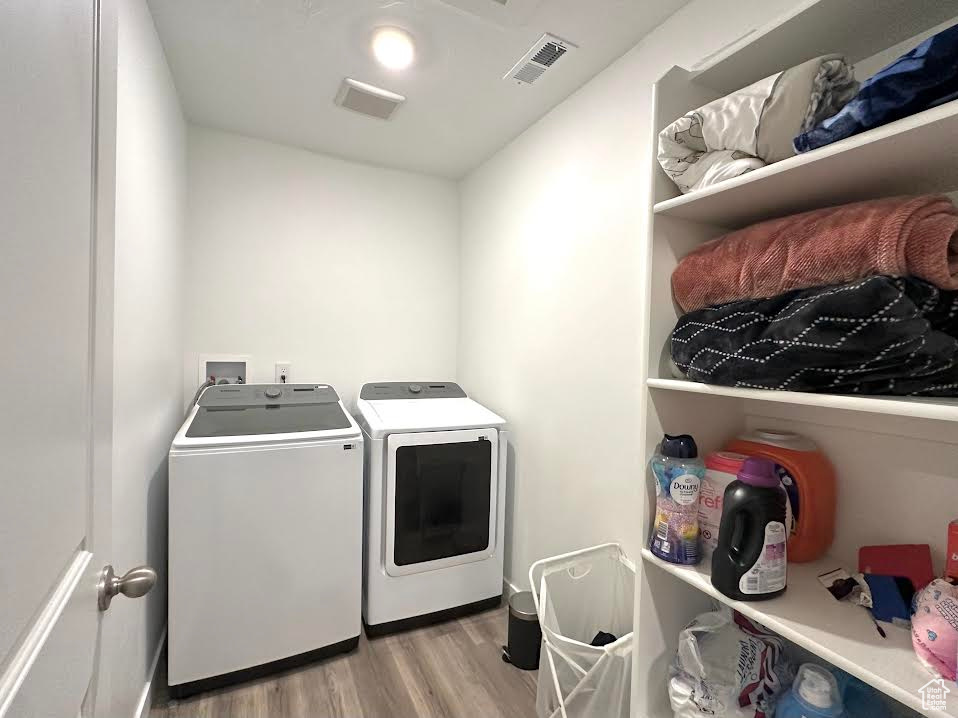 Laundry room featuring light hardwood / wood-style flooring and washer and dryer