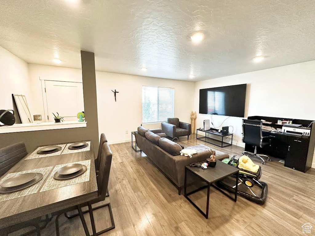 Living room with a textured ceiling and light wood-type flooring