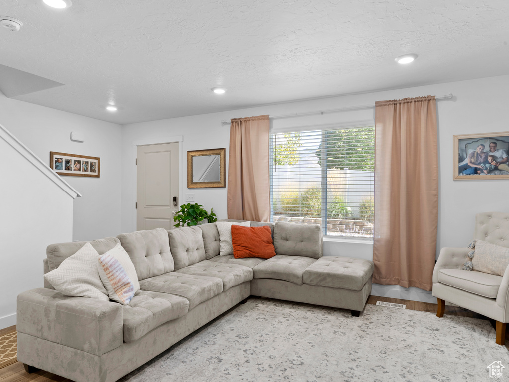 Living room with a textured ceiling and hardwood / wood-style flooring