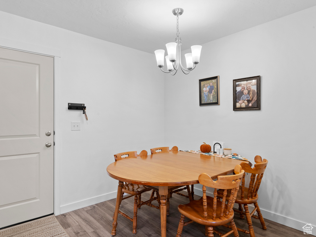 Dining room with a notable chandelier and wood-type flooring