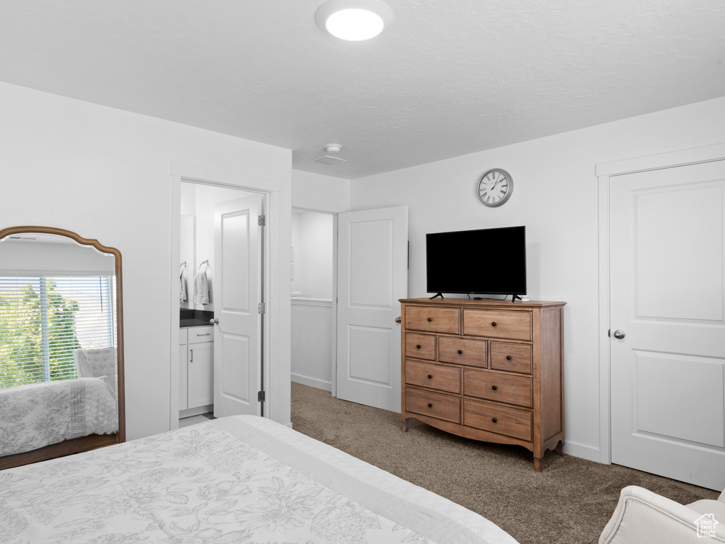 Bedroom with ensuite bathroom and carpet floors