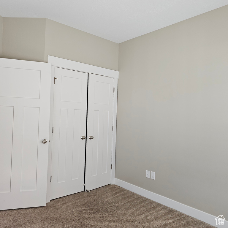 Unfurnished bedroom with a closet and carpet floors