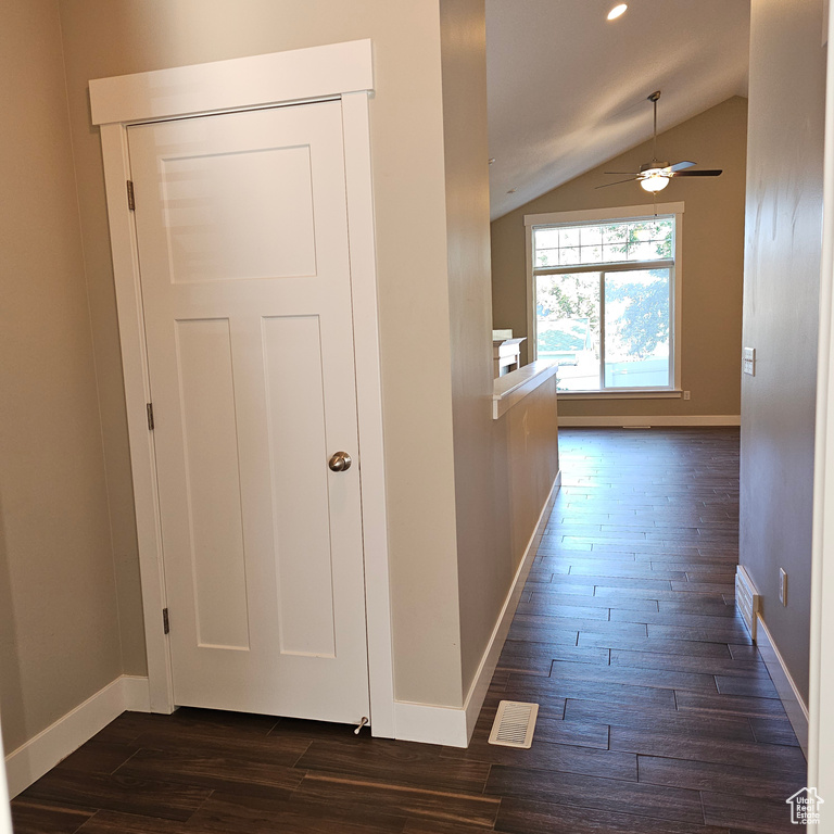 Corridor featuring dark wood-type flooring and lofted ceiling