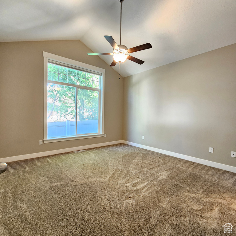 Unfurnished room with ceiling fan, carpet, and vaulted ceiling