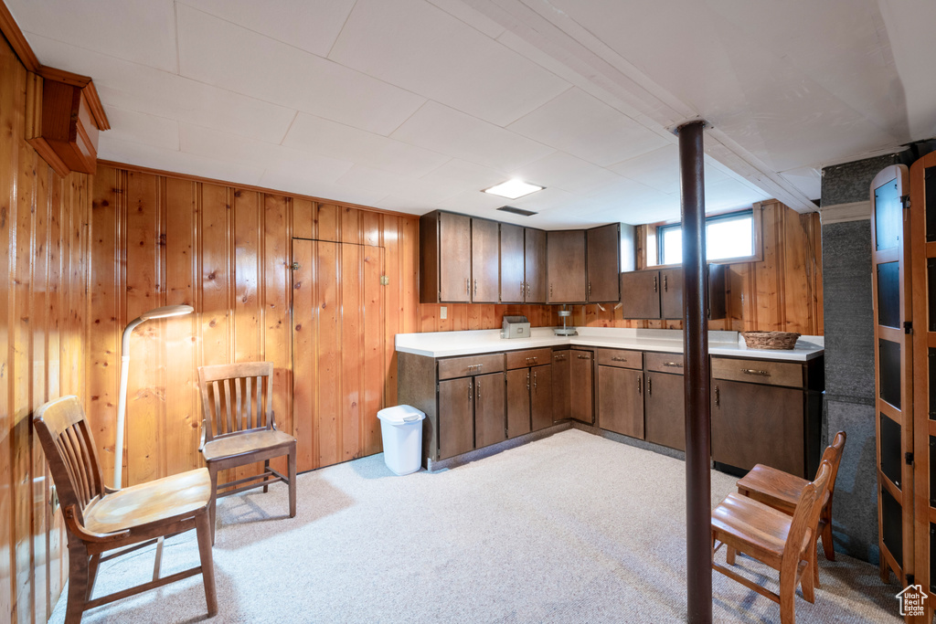 Kitchen with light carpet and wood walls