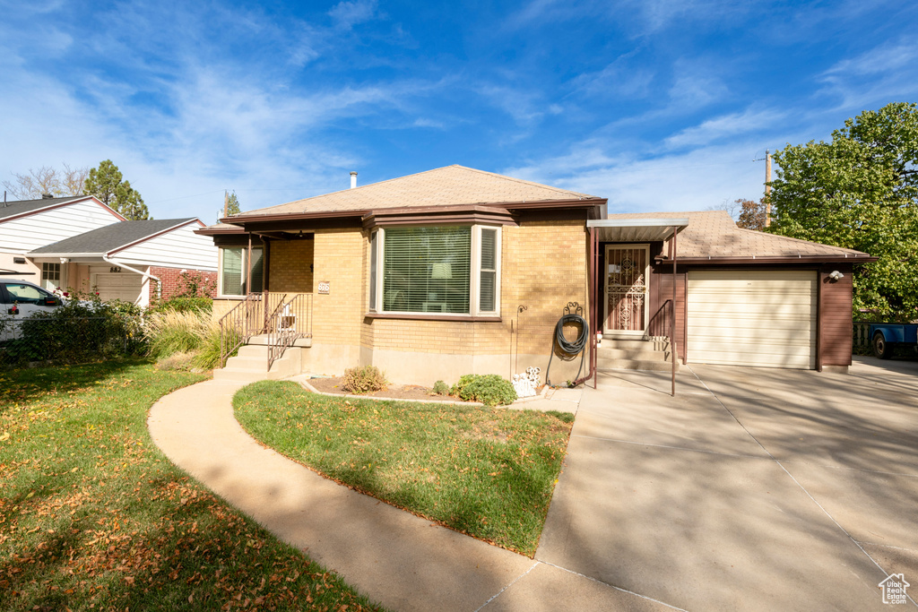 View of front facade with a front yard and a garage