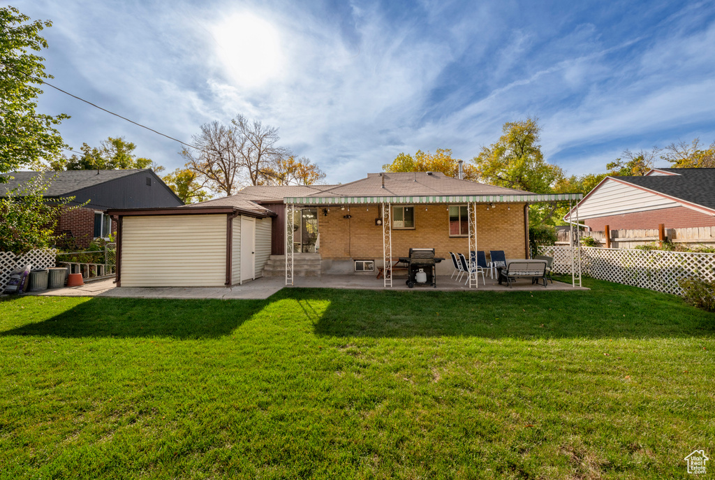 Rear view of house featuring a yard and a patio