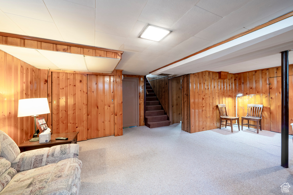 Sitting room featuring wood walls and carpet floors