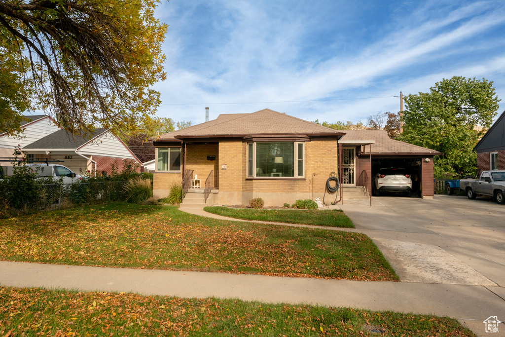 View of front of house featuring a front yard and a carport